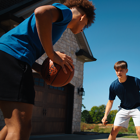 Two male models playing basketball against each other with the Spalding Zi/O Basketball. 